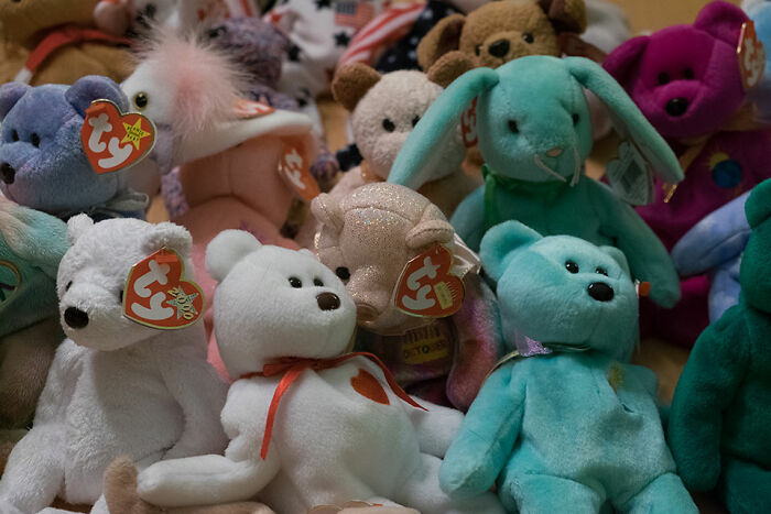 Several vintage Beanie Babies plush toys in various colors and shapes representing a popular fad from the 1990s.