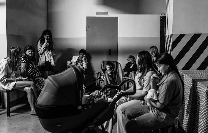 Black and white scene showing a group of people in a room, capturing the essence of humanity in 2024.