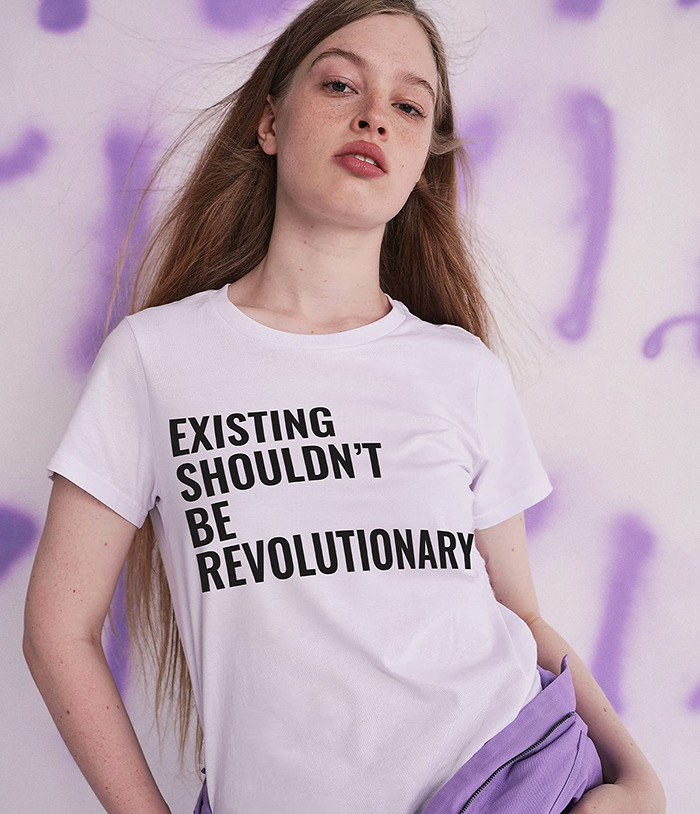 Vivian Musk wearing statement shirt in modeling debut, sparking buzz as Elon Musk's trans daughter in fashion scene.