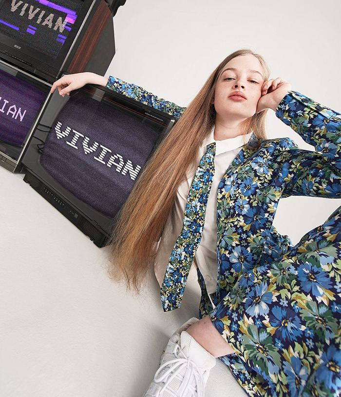 Vivian Musk posing in floral suit during modeling debut, sparking buzz as Elon Musk's trans daughter in fashion industry.