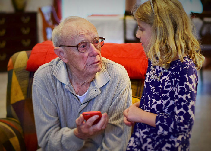 Elderly man talking to a young girl, capturing moments that reflect parents' worst kids' behavior in public.