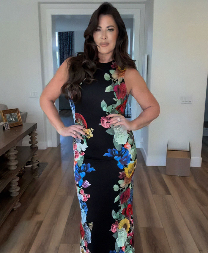 Woman in a floral black dress posing indoors amid discussions about Ozempic tongue side effects from weight-loss meds.