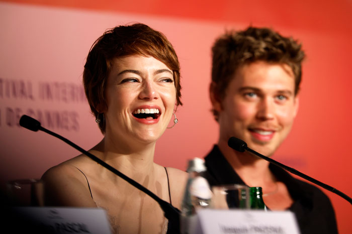 Emma Stone laughing during a Cannes press event, responding to a reporter calling her by her real name.