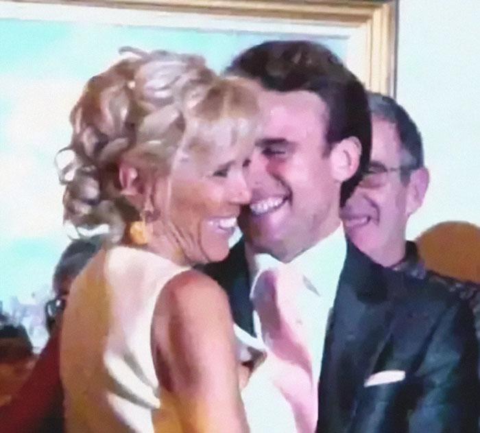 French President Emmanuel Macron and his wife smiling closely at a public event after shoving incident.