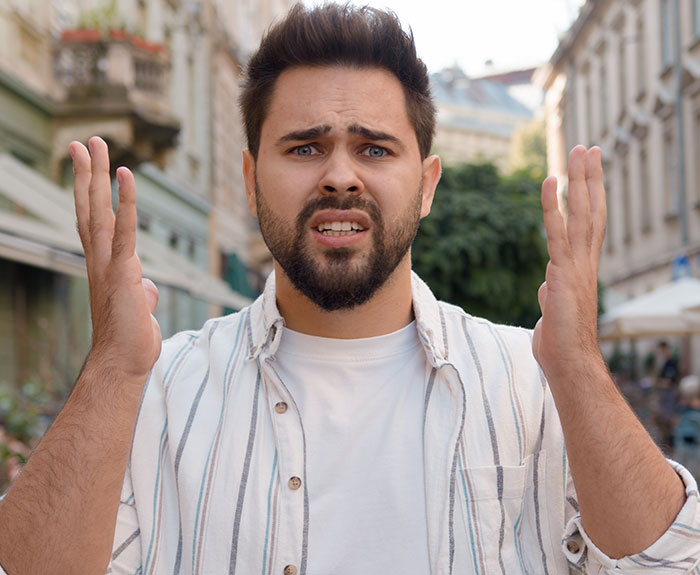 Young man looking frustrated and confused outdoors, illustrating a millionaire running out before paying the bill concept.