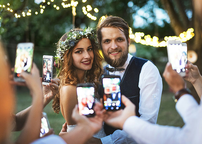 Bride and groom posing for wedding photos outdoors, highlighting woman's wedding revenge and controversy.