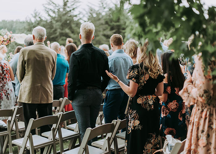 Guests at an outdoor wedding ceremony, highlighting a woman's wedding revenge and controversy involving another woman.