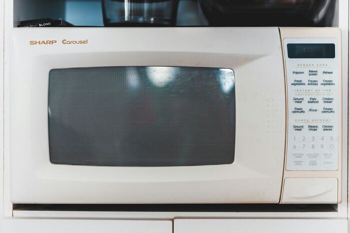 White Sharp Carousel microwave with digital control panel, illustrating useful kitchen life hacks for everyday common knowledge.