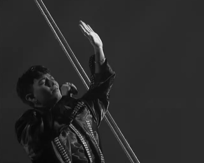 Singer performing in a dramatic moment during Austria clinches Eurovision 2025 victory with stunning performance.