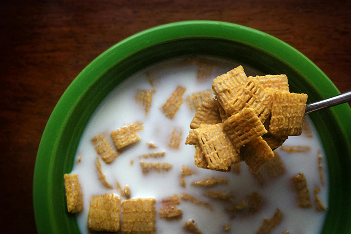 Bowl of cereal squares with milk on a wooden table, illustrating unsettling pregnancy and birth facts.