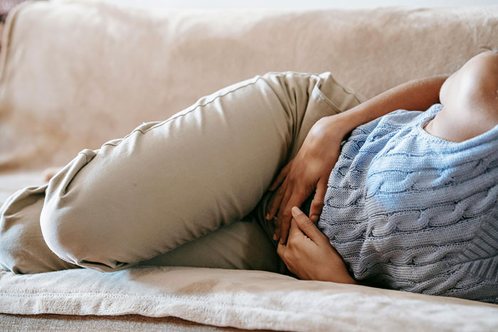 Pregnant woman lying on a couch holding her belly, illustrating facts about pregnancy and birth experiences.