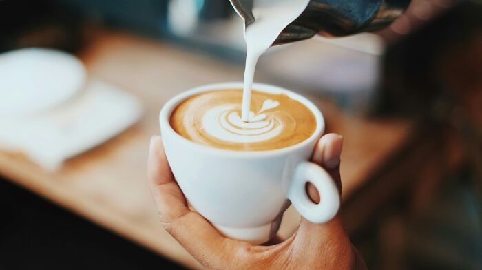 Close-up of latte art being poured into a cup, illustrating one of the mind-boggling beliefs that smart people hold.
