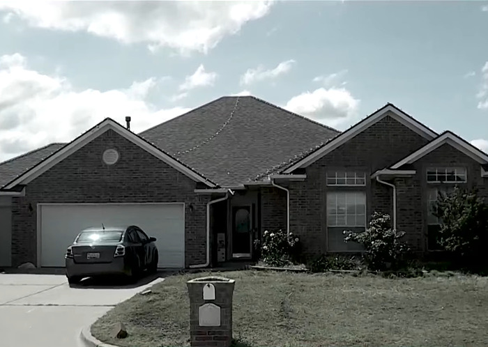 Suburban brick house with a car parked outside, representing a family affected by ICE agents raiding the wrong home.