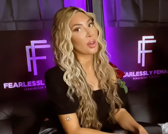 Farrah Abraham posing indoors with long wavy hair, wearing a black top during a Fearlessly Female event.
