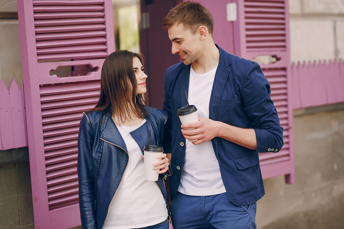 Young man and woman sharing coffee while smiling, illustrating stories of ultimatums and lost friendships.