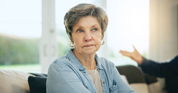 Older woman looking upset and distant during a conversation about people who called off their wedding and breakup reasons.