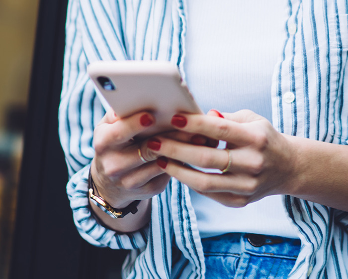 Person with red nails holding a phone, typing final heartbreaking texts from tourist abducted at vacation hotspot Person with red nails holding a phone, typing final heartbreaking texts from tourist abducted at vacation hotspot