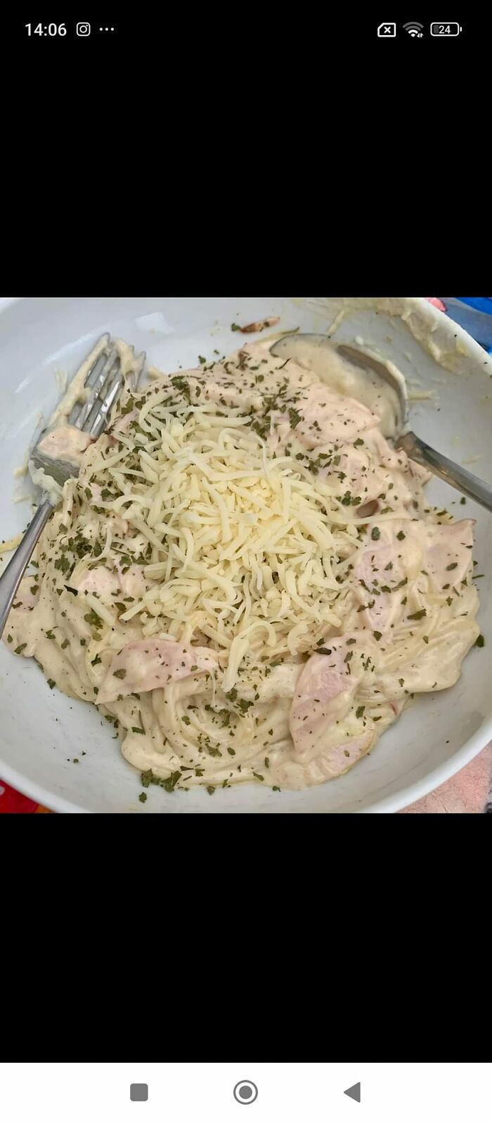 Creamy cheesy pasta with herbs and chicken in a bowl, an example of cursed food pics that should come with a trigger warning