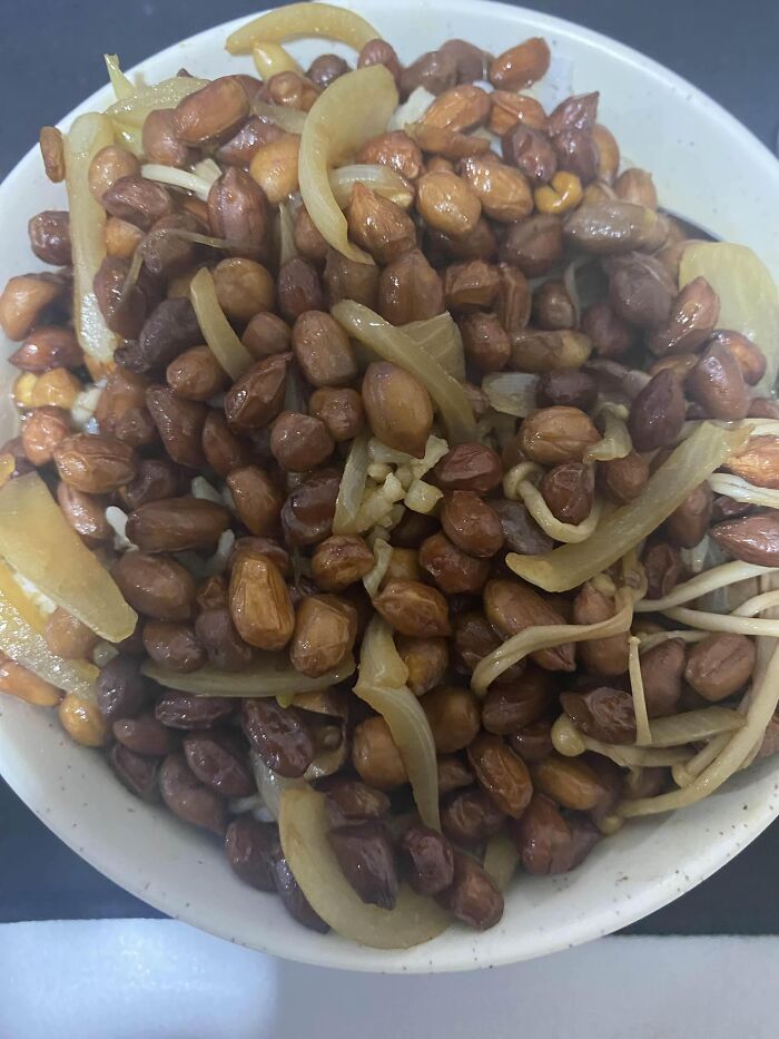 Bowl of cooked peanuts with onions and bean sprouts, an example of cursed food pics that may cause discomfort.