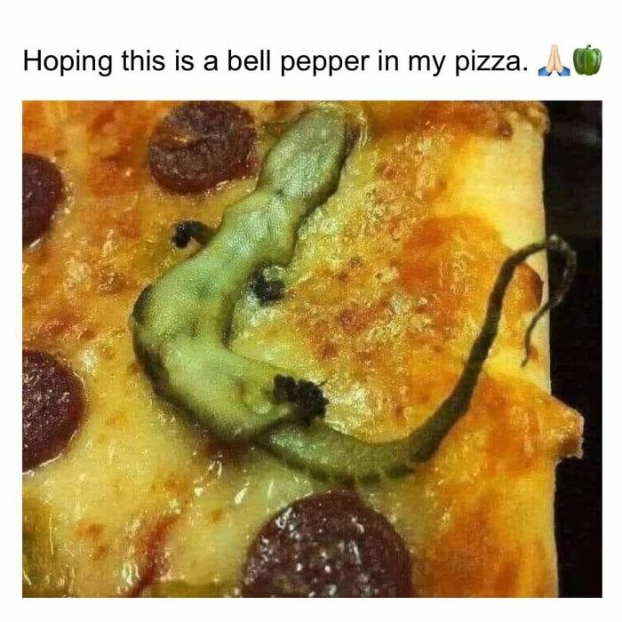 A close-up of a pizza slice with a strange, green, cursed food pic resembling an unusual pepper topping.