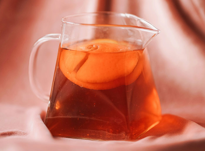 Glass pitcher of iced tea with lemon slice, illustrating funny things foreigners say about the United States by Americans.