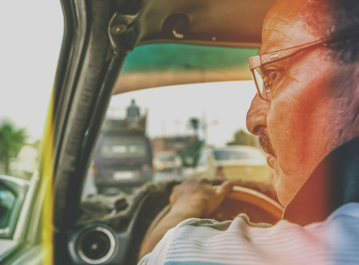 Middle-aged man driving a car, capturing a moment for 60 Americans recalling funniest things foreigners said about the US.