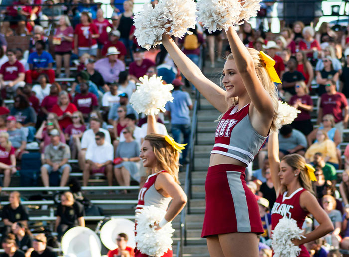 Cheerleaders performing at a crowded stadium, capturing the funniest things foreigners have said about the United States.