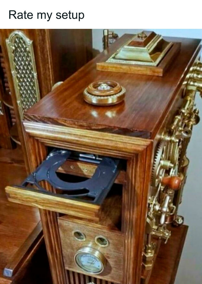 Steampunk-inspired wooden device with gears and dials, featuring an unusual compact disc drive setup in blursed design.