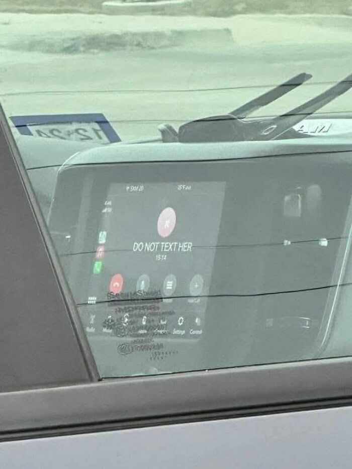 Car dashboard screen showing a call with contact named DO NOT TEXT HER in a weird pics or it didn’t happen moment.
