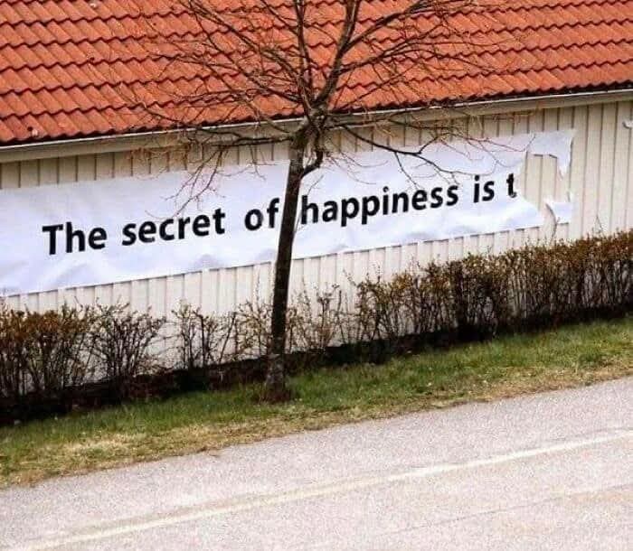 Banner with a partially covered motivational quote on a house wall, showcasing weird pics or it didn’t happen moments.