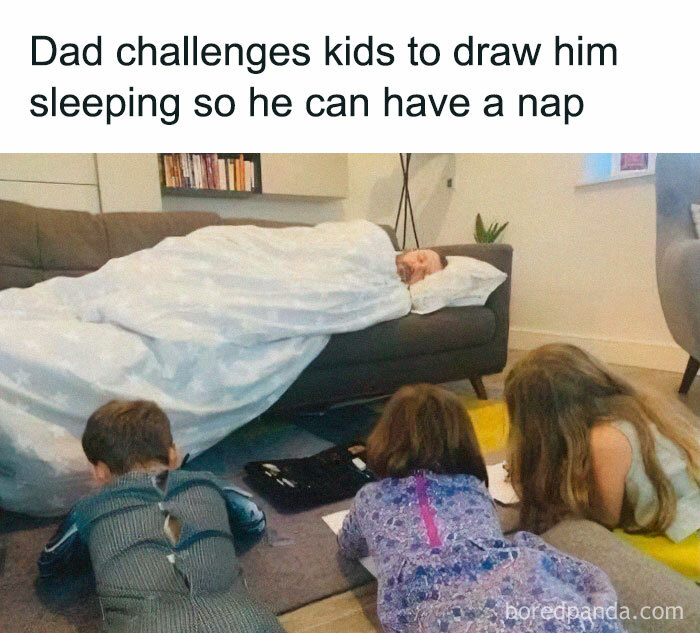 Dad lying on a couch pretending to sleep while kids draw him in a cozy living room scene random memes humor.