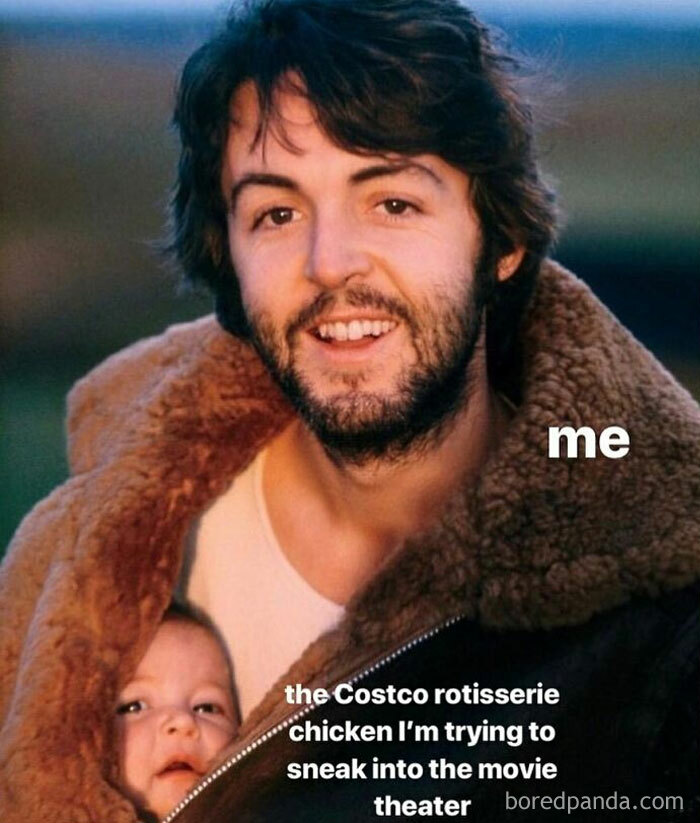 Man with beard smiling, carrying baby inside jacket, funny parenting meme about sneaking Costco rotisserie chicken into theater.