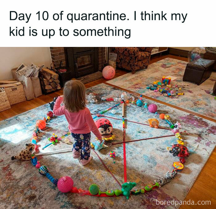 Child standing inside a circle of toys arranged on a carpet, illustrating funny parenting memes that are painfully relatable.