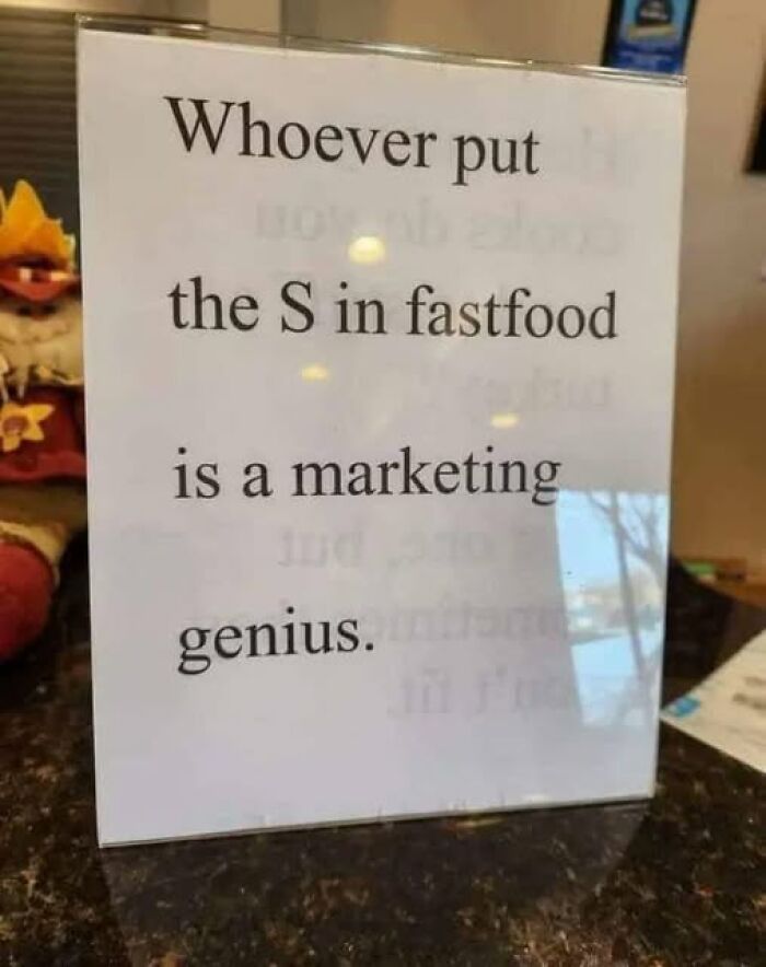 Sign humorously praising the marketing genius who added an S to fastfood, related to vegan and Impossible meme culture.