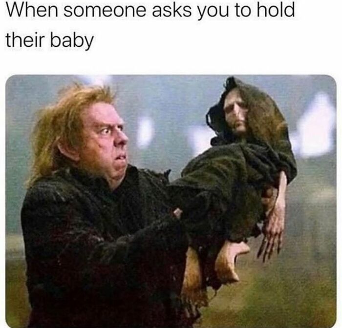 A man with a shocked expression awkwardly holding a creepy doll, capturing random memes delivering hilarious nonsense humor.