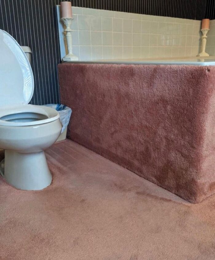 Bathroom with pink carpet covering floor and bathtub, an example of worst real estate photos ever showing unusual home features.