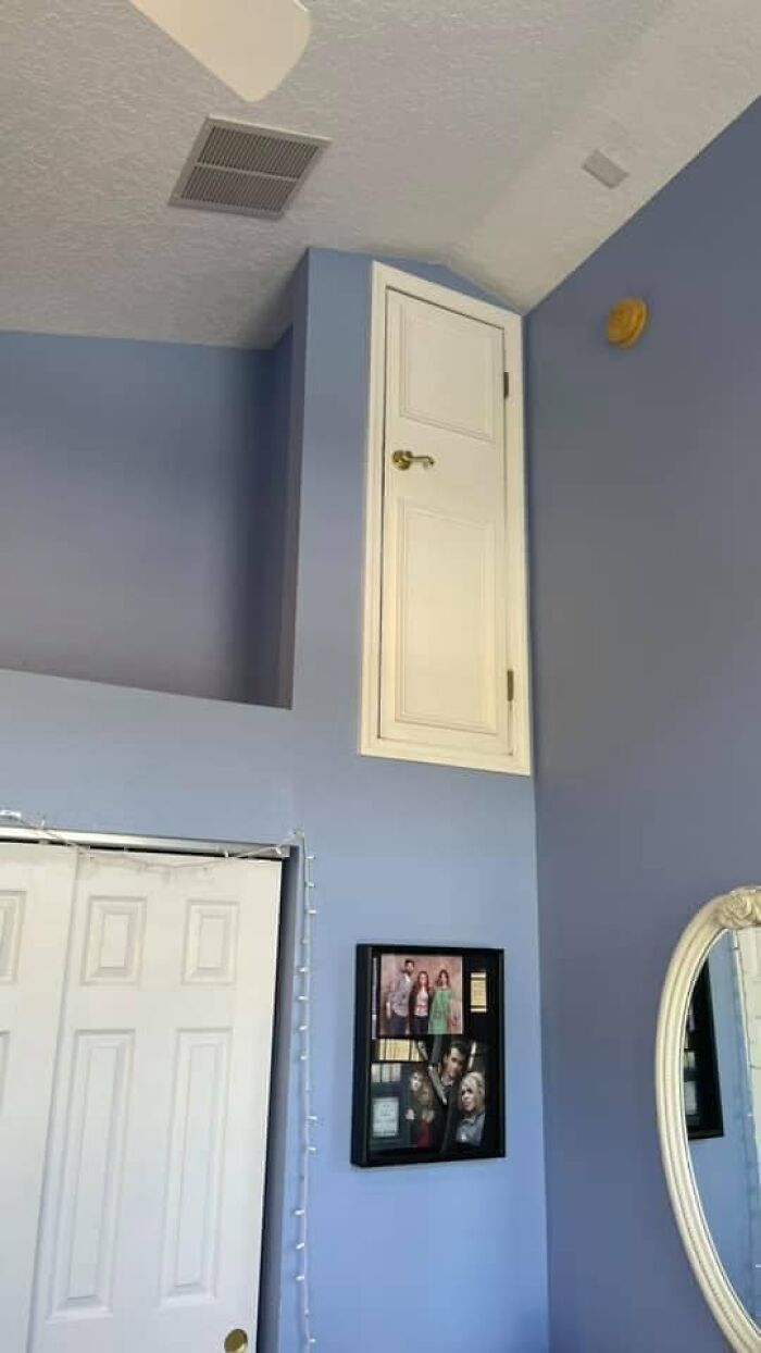 Unusable tiny door located high on a blue wall in a home, illustrating one of the worst real estate photos ever.