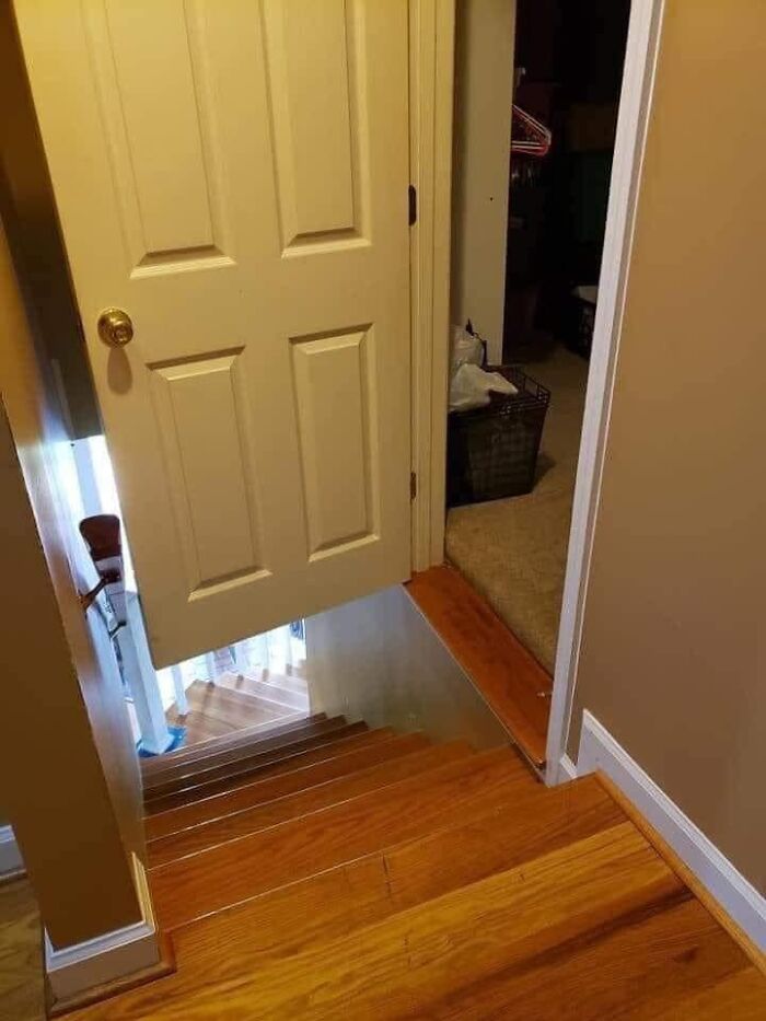 Door opening directly over a steep stairway in a home, an example of worst real estate photos ever and unsafe design.