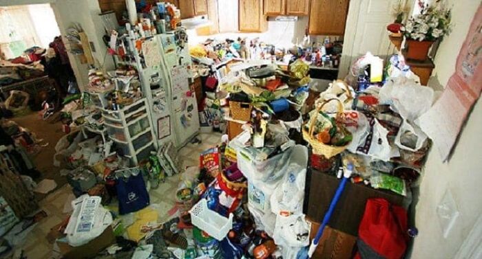 Cluttered and messy kitchen filled with trash and household items, showcasing one of the worst real estate photos ever.