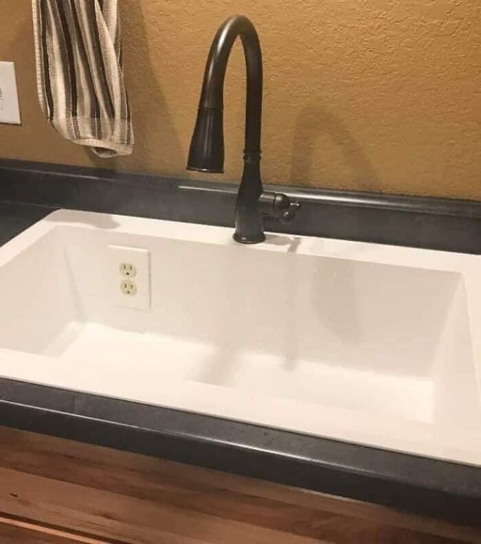 Kitchen sink with a power outlet installed inside the basin, illustrating one of the worst real estate photos ever mistakes.