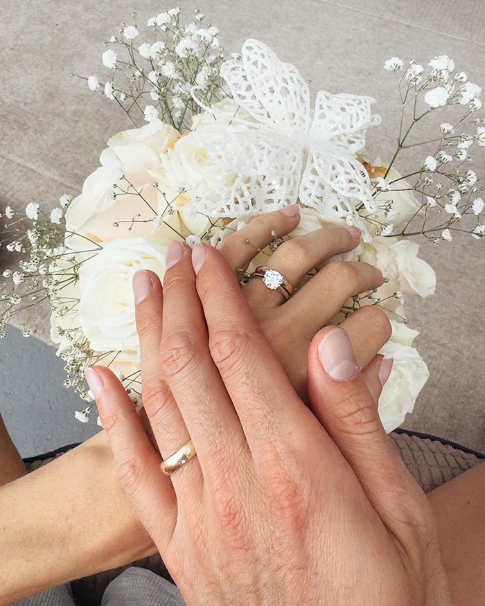 Hands with wedding rings over a white flower bouquet, symbolizing the union of 25 year-old pro boxer Georgia O&rsquo;Connor.