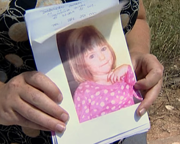 Person holding a photo of Madeleine McCann in a pink polka dot shirt related to German police urgent request.