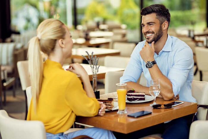 A man and woman smiling while having dessert and drinks, representing small decisions that changed life forever.