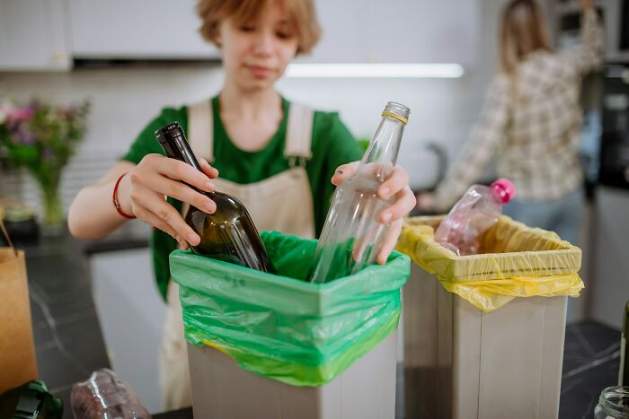 Person sorting recyclable bottles into bins, illustrating company secret insights shared after no longer working there.