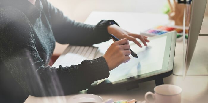 Person using a stylus on a digital drawing tablet, illustrating creative ways to earn quick money remotely.