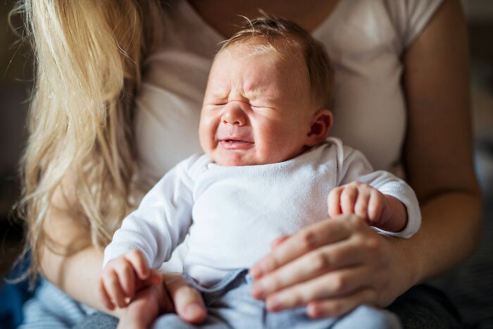 Newborn baby crying in mother's arms, illustrating emotional impact of soul-crushing things parents say to children.