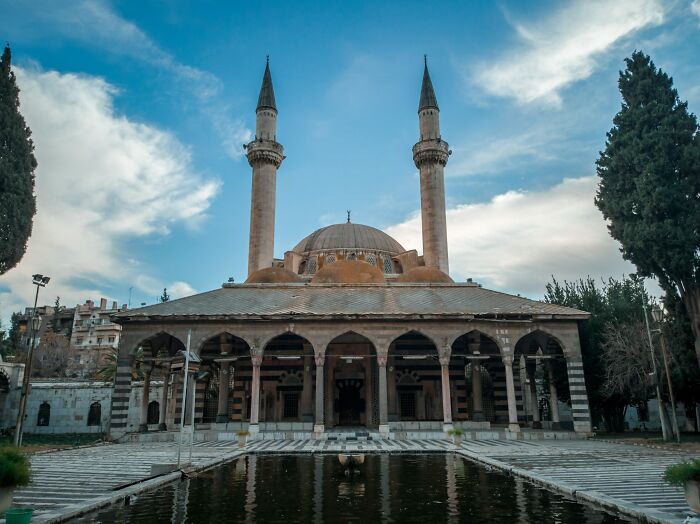Historic mosque with twin minarets and reflecting pool, an example of tourist destinations once popular but now fallen into oblivion.