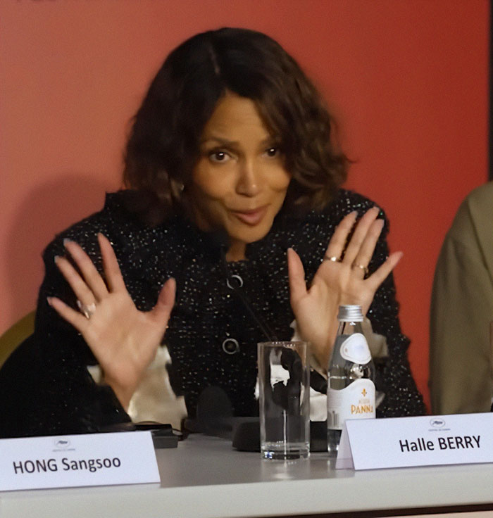 Halle Berry speaking at a Cannes event, reacting with hands raised amid new dress code enforcement. Halle Berry speaking at a Cannes event, reacting with hands raised amid new dress code enforcement.