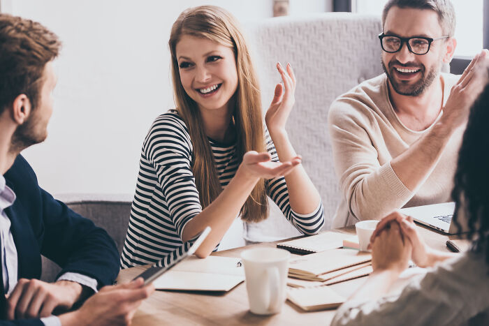 A group of adults discussing childhood habits and red flags in a bright, casual meeting setting.