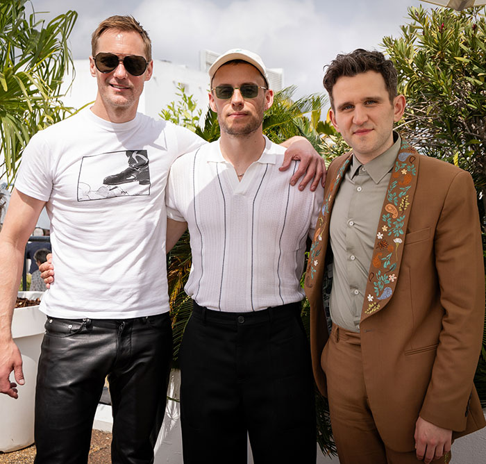 Three men posing outdoors, one wearing a Harry Potter star-themed outfit, related to x-rated gay film with graphic scenes.
